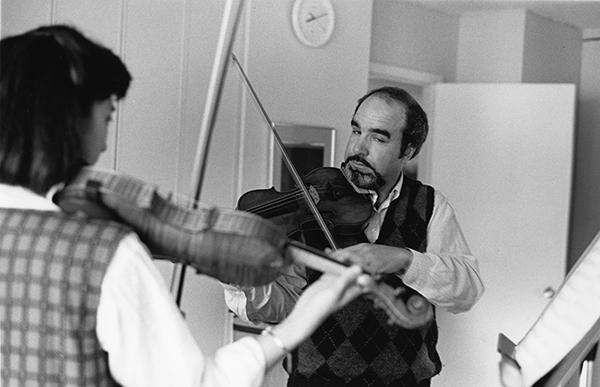 man with violin teaching a student